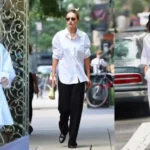 Woman styling oversized white shirt with tailored trousers, belt, and summer accessories for chic summer fashion look