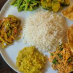 Traditional Indian staples including moong dal, dalia, rajma, turmeric, amla, bottle gourd, and lentils arranged in bowls.